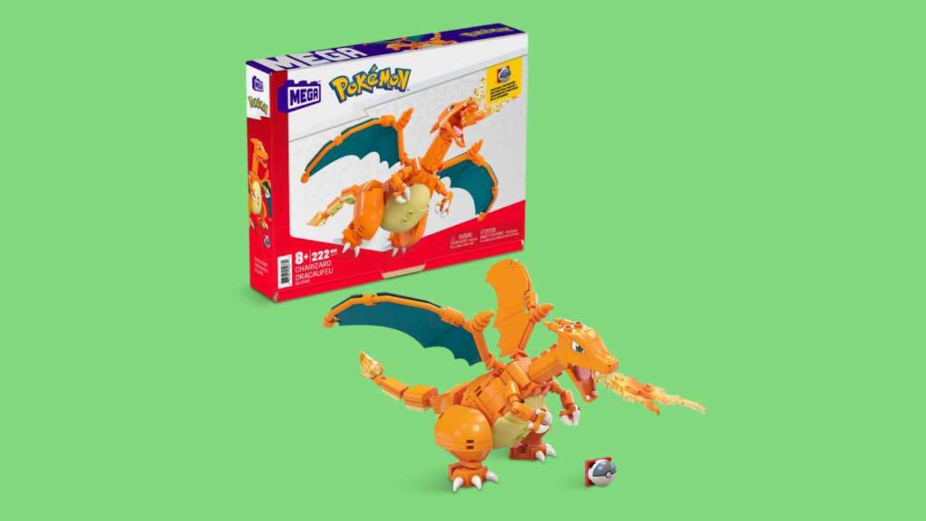 Mega Charizard against a green background. The boxart is just behind the model.