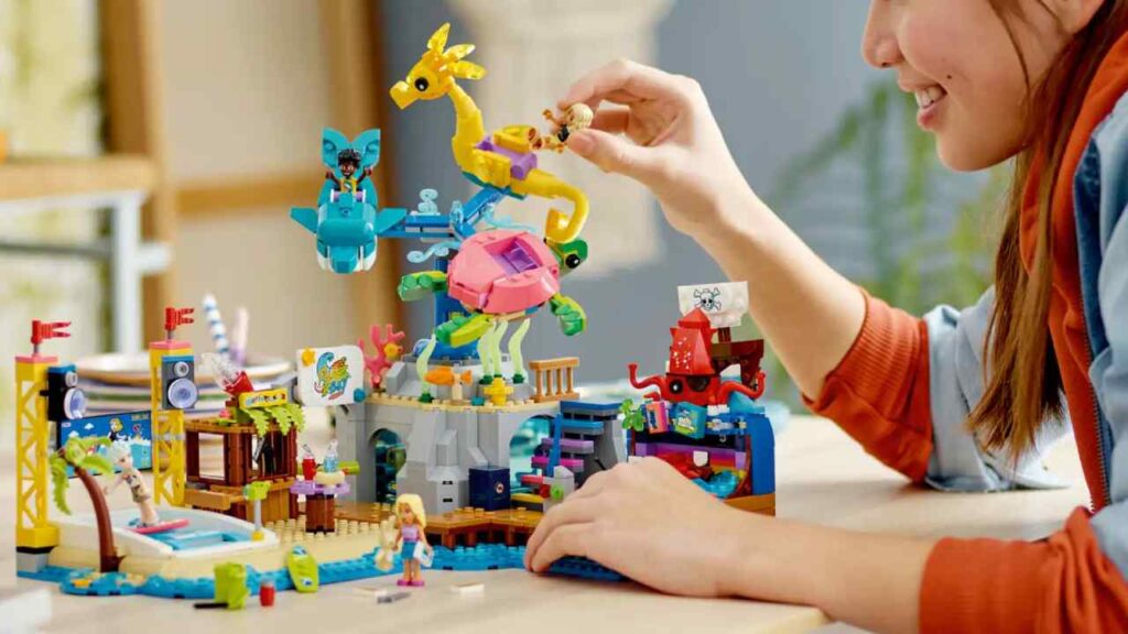 A child is playing with the LEGO Friends Beach Amusement Park set.