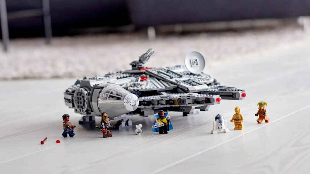 The Millenium Falcon is placed on the floor, with 6 minifigures surrounding it.