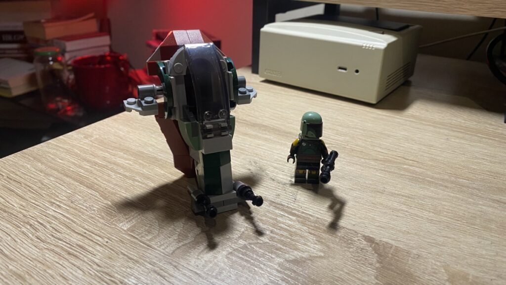 The 75344 LEGO Star Wars Boba Fett’s Starship Microfighter is next to a Boba Fett minifigure.